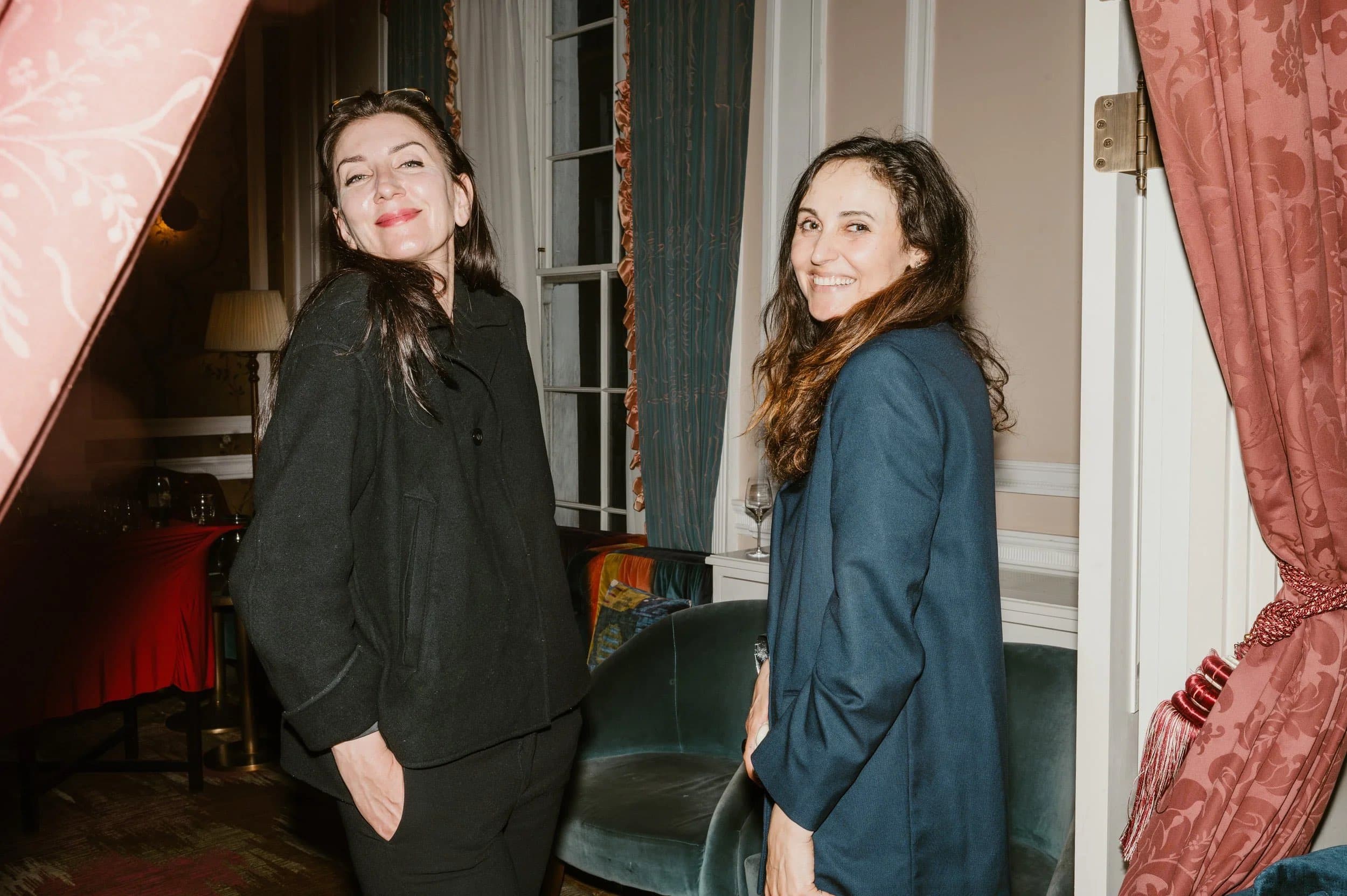 Two guests laughing together at a London launch event