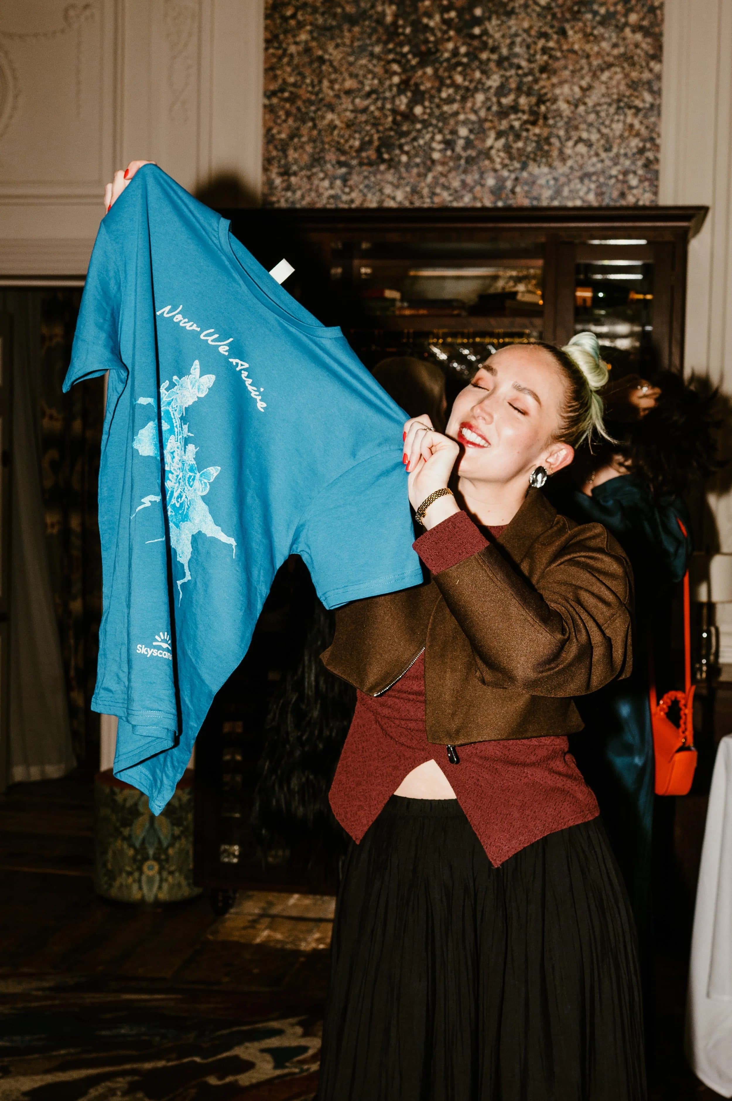 A guest holding up a printed campaign T-shirt at a launch event
